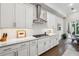 Bright kitchen features white cabinets, stainless steel hood, and herringbone backsplash at 642 Stickley Oak Way, Woodstock, GA 30189