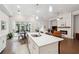 Open concept kitchen with island, white cabinets, view to the patio, and a cozy living area with a fireplace at 642 Stickley Oak Way, Woodstock, GA 30189