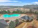 Aerial view of a community pool area featuring a uniquely shaped pool, clubhouse, and playground at 1305 Lanier Ct, Hampton, GA 30228