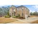 Charming two-story brick home with manicured landscaping, a two car garage, and a lawn at 1305 Lanier Ct, Hampton, GA 30228