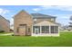 A rear view of a brick two-story home featuring a screened-in porch and a well-maintained lawn at 1305 Lanier Ct, Hampton, GA 30228