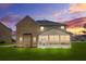 A rear view of a brick two-story home featuring a screened-in porch under a dramatic sunset at 1305 Lanier Ct, Hampton, GA 30228