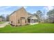 A view of the rear exterior of a home showing the brick, yard and screened-in porch at 1305 Lanier Ct, Hampton, GA 30228