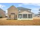 A rear view of a brick two-story home featuring a screened-in porch and dormant lawn at 1305 Lanier Ct, Hampton, GA 30228