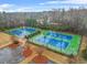 Overhead view of well-maintained tennis courts with vibrant blue surfaces and manicured green surroundings at 1305 Lanier Ct, Hampton, GA 30228