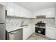 Modern kitchen with white cabinets, stainless steel appliances, and hexagon tile backsplash at 1501 Clairmont Rd # 1624, Decatur, GA 30033