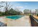 Outdoor pool is covered for the winter surrounded by lush greenery and a black fence at 1501 Clairmont Rd # 1624, Decatur, GA 30033