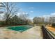 Outdoor pool is covered for the winter surrounded by lush greenery and a black fence at 1501 Clairmont Rd # 1624, Decatur, GA 30033