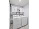 Functional laundry room with washer, dryer, cabinets, shelves, and stylish tile flooring at 1905 Countryside Se Pl # 1905, Smyrna, GA 30080