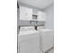 Bright laundry room featuring a washer, dryer, white cabinets, and shelving above machines at 1905 Countryside Se Pl # 1905, Smyrna, GA 30080