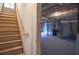 Stairs lead to unfinished basement with a garage door, a trash can, and utilities at 1975 Skidmore Cir, Lawrenceville, GA 30044