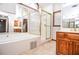 Bright bathroom with a tiled tub, separate shower, and patterned wallpaper creating a serene space at 1975 Skidmore Cir, Lawrenceville, GA 30044