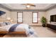 Well-lit bedroom features a ceiling fan, natural light, and minimalist decor at 1975 Skidmore Cir, Lawrenceville, GA 30044