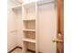 Walk in closet featuring multiple built-in shelving units and wooden trim at 1975 Skidmore Cir, Lawrenceville, GA 30044