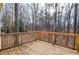 Wooden deck overlooks a beautiful wooded area with a railing on the perimeter at 1975 Skidmore Cir, Lawrenceville, GA 30044