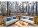 Outdoor deck area with two matching sofas and coffee table surrounded by trees at 1975 Skidmore Cir, Lawrenceville, GA 30044