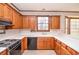 Eat-in kitchen with wood cabinets, white countertops and tile flooring at 1975 Skidmore Cir, Lawrenceville, GA 30044