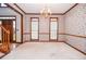 Formal living room featuring elegant chandelier, wood trim, and neutral carpet at 1975 Skidmore Cir, Lawrenceville, GA 30044