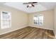 This bedroom features wood floors, a ceiling fan, and large windows for natural light at 241 The Esplanade Se Way, Loganville, GA 30052