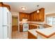 Functional kitchen with white appliances, wood cabinets, and a tile floor at 241 The Esplanade Se Way, Loganville, GA 30052