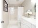 Bright bathroom with white vanity, white tile floor, and a combination shower and tub at 970 Winding Creek Trl, Atlanta, GA 30328