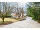 Long driveway leading to a home nestled amongst mature trees and lush landscaping at 970 Winding Creek Trl, Atlanta, GA 30328