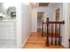 Hallway with hardwood floors, wooden banister, and view of updated bathroom with decorative mirror at 970 Winding Creek Trl, Atlanta, GA 30328