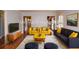 Bright living room with modern staging, including two yellow chairs and a navy couch at 970 Winding Creek Trl, Atlanta, GA 30328