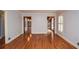 Empty living room with hardwood floors, neutral walls, and multiple entryways at 970 Winding Creek Trl, Atlanta, GA 30328