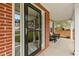 Close-up of a welcoming front porch with seating and a black screen door framed by brick at 1925 Barnett West Ct, Buford, GA 30518