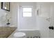 Clean bathroom featuring granite countertop vanity and shower-tub combo with white tile surround at 412 E Pharr Rd, Decatur, GA 30030