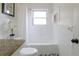 Well-lit bathroom featuring white tiles, granite countertop, modern fixtures, and a shower-tub combo at 412 E Pharr Rd, Decatur, GA 30030