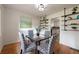 Bright dining room with modern shelving, glass table, and patterned chairs next to the updated kitchen at 412 E Pharr Rd, Decatur, GA 30030