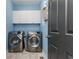 Efficient laundry room with side-by-side washer and dryer and overhead cabinets at 6220 Crofton Dr, Alpharetta, GA 30005