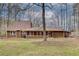 View of the back of the home with a spacious yard and mature trees at 120 Arrowood Ln, Alpharetta, GA 30009