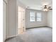 Spacious carpeted bedroom with ceiling fan, two windows, and access to hall at 120 Arrowood Ln, Alpharetta, GA 30009