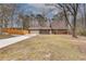 Ranch home with an attached garage and a long driveway surrounded by mature trees at 120 Arrowood Ln, Alpharetta, GA 30009