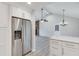 Open-concept kitchen with stainless steel refrigerator adjacent to living space featuring a stone fireplace at 120 Arrowood Ln, Alpharetta, GA 30009