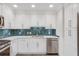 Bright, updated kitchen with sleek, white cabinetry, stainless appliances, and stylish herringbone backsplash at 120 Arrowood Ln, Alpharetta, GA 30009
