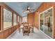 A cozy sunroom featuring a wood-paneled wall, a ceiling fan, and a view of the backyard at 120 Arrowood Ln, Alpharetta, GA 30009