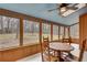 A sunroom with a light blue ceiling, wood-paneled walls, and multiple windows providing views of the surrounding trees at 120 Arrowood Ln, Alpharetta, GA 30009