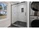 Modern bathroom featuring a glass shower with black trim and a stacked washer and dryer set at 207 Garrison Se Rd, Marietta, GA 30008
