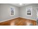 Bedroom featuring hardwood floors, neutral paint, and two bright windows at 207 Garrison Se Rd, Marietta, GA 30008