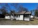Quaint one-story home with a screened-in porch, neutral siding and mature trees at 207 Garrison Se Rd, Marietta, GA 30008