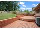 Large wooden deck with built-in seating and planters surrounded by mature trees at 3710 Oregon Trl, Decatur, GA 30032