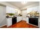 Well-lit kitchen with white cabinets, black appliances, tile backsplash, and wood floors at 3710 Oregon Trl, Decatur, GA 30032