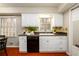 Kitchen with white cabinets, black appliances, tile backsplash, and wood floors at 3710 Oregon Trl, Decatur, GA 30032