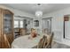 Dining area featuring chandelier, table set for six, and open view to living room at 5555 Sugar Crossing Dr, Sugar Hill, GA 30518