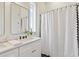 Clean bathroom features a double vanity, shower curtain, and a bright window at 100 5Th St, Fayetteville, GA 30214