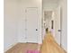 Bright hallway with hardwood floors featuring white walls and multiple doors leading to other rooms at 100 5Th St, Fayetteville, GA 30214